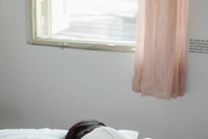 woman lying on bed near window